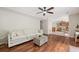 Spacious living room featuring hardwood floors, fan, and ample natural light open to kitchen at 8112 Halifax Way, North Charleston, SC 29420