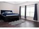 Spacious bedroom with dark wood floors, large windows, and a cozy rug at 8127 Saveur Ln, Charleston, SC 29406