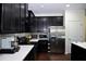 Modern kitchen features black cabinets, stainless steel appliances, and white countertops at 8127 Saveur Ln, Charleston, SC 29406
