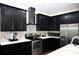 Well-lit kitchen with stainless steel appliances, black cabinets, and stylish backsplash at 8127 Saveur Ln, Charleston, SC 29406