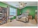 Inviting bedroom featuring ceiling fan, window, crib, shelving, and comfortable bed at 9101 Parlor Dr, Ladson, SC 29456