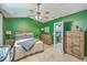 Spacious bedroom with hardwood furniture, ceiling fan, and an ensuite bathroom offering comfort and functionality at 9101 Parlor Dr, Ladson, SC 29456