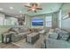 Relaxing living room with comfortable grey couches, a ceiling fan, and an open view to the kitchen at 9101 Parlor Dr, Ladson, SC 29456