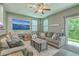 Inviting living room with a comfortable grey sofa, ceiling fan, and a large TV for entertainment at 9101 Parlor Dr, Ladson, SC 29456