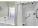 Bright, accessible bathroom with a soaking tub with a clear window, and an accessible shower with curtain and built-in seat at 9133 Markleys Grove Blvd, Summerville, SC 29485