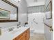 Accessible bathroom with a large mirror, updated vanity, and accessible shower with grab bars and seat at 9133 Markleys Grove Blvd, Summerville, SC 29485