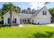 Charming single-story home with a well-manicured lawn, palm tree, and inviting front porch at 9133 Markleys Grove Blvd, Summerville, SC 29485