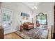 Cozy living room with a comfortable loveseat, stylish rug, and natural light from the door and arched window at 9133 Markleys Grove Blvd, Summerville, SC 29485