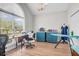 Bright office space with a large window, blue cabinets, a sewing machine, and an ironing board at 9133 Markleys Grove Blvd, Summerville, SC 29485