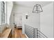 Hallway view shows light-colored wood floors, white shiplap walls, black metal handrail and a bedroom in background at 922 Kincade Dr, Mount Pleasant, SC 29464