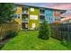 View of the backyard with colorful townhouses and a well-manicured lawn at 9305 Sweetbay Ct, Ladson, SC 29456