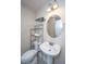 Well lit bathroom featuring a round mirror, pedestal sink, and a shelf for storage at 9305 Sweetbay Ct, Ladson, SC 29456