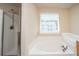 Bathroom showcasing a soaking tub and a separate glass-enclosed shower at 9305 Sweetbay Ct, Ladson, SC 29456