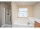 Bathroom showcasing a soaking tub and a separate glass-enclosed shower at 9305 Sweetbay Ct, Ladson, SC 29456