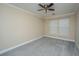 Bedroom with neutral walls, gray carpet, a ceiling fan and white trim around the window at 9305 Sweetbay Ct, Ladson, SC 29456