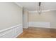 Elegant dining room featuring hardwood floors, wainscoting, and a stylish chandelier at 9305 Sweetbay Ct, Ladson, SC 29456