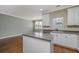 Bright kitchen with white cabinets, stainless steel appliances, and an island overlooking the adjacent living area at 9305 Sweetbay Ct, Ladson, SC 29456