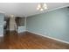 Bright living room featuring hardwood floors, crown molding, and a modern light fixture with stairway view at 9305 Sweetbay Ct, Ladson, SC 29456