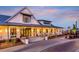 Welcoming view of the lakehouse entrance with brick pavers, columns, covered porch, and a charming, well-lit facade at 99 French Garden Cir, Summerville, SC 29486