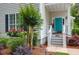 Close up of home's entrance featuring a vibrant turquoise door and manicured landscaping at 1025 Mathis Ferry Rd, Mount Pleasant, SC 29464