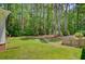 Serene backyard with lush grass, trees, and a small fence at 107 Kimberwicke Dr, Summerville, SC 29483
