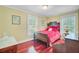A bedroom features a wood bed frame with red bedding, yellow walls, and hardwood floors at 107 Kimberwicke Dr, Summerville, SC 29483