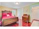 A bedroom features a wood bed frame, red bedding, an antique dresser, and hardwood floors at 107 Kimberwicke Dr, Summerville, SC 29483
