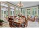 Sunlit dining area with multiple windows, wood floors, a chandelier and forest views at 107 Kimberwicke Dr, Summerville, SC 29483