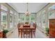 Bright sunroom dining area with large windows offering tranquil outdoor views and tile floors at 107 Kimberwicke Dr, Summerville, SC 29483