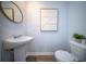 Well-lit powder room with pedestal sink, decorative mirror, modern artwork, and updated fixtures at 108 Rosefield Ct, Summerville, SC 29485