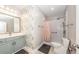 Bathroom with a grey vanity, decorative wallpaper, and a tiled shower with a peach curtain at 1121 Basildon Rd, Mount Pleasant, SC 29466