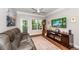 Comfortable living room with a leather sofa, view to the balcony and dark wood media cabinet at 1121 Basildon Rd, Mount Pleasant, SC 29466