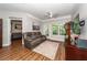 Inviting living room with crown molding, ceiling fan, wood floors, and a comfortable leather sofa at 1121 Basildon Rd, Mount Pleasant, SC 29466