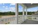 A covered balcony with white railings and columns showcasing an outdoor view with trees and blue skies at 116 Midmills Ln, Summerville, SC 29486