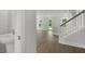 Hallway with gray floors, a powder room, and stairs leading to the next floor of the home at 116 Midmills Ln, Summerville, SC 29486