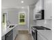 Bright kitchen with white cabinets, stainless steel appliances, quartz counters, and view of the backyard at 116 Midmills Ln, Summerville, SC 29486