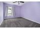 Empty bedroom with purple walls, grey carpet, and a window that gives a view of the neighborhood at 117 Ducane St, Summerville, SC 29483