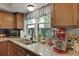 Charming kitchen features granite countertops, stainless sink, and a view to the backyard at 125 Crooked Creek Ct, Summerville, SC 29486