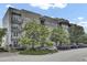 Beautiful exterior of a multi-story condo building with balconies and mature trees at 125 Pier View St # 209, Charleston, SC 29492
