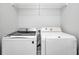Well-lit laundry room with modern washer and dryer units and overhead wire shelving for storage at 125 Pier View St # 209, Charleston, SC 29492