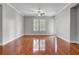 Bright living room with hardwood floors, a ceiling fan, and a door leading to a balcony or outdoor space at 125 Pier View St # 209, Charleston, SC 29492