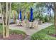 Outdoor patio with dining tables, sun umbrellas, and a built in grill at 125 Pier View St # 209, Charleston, SC 29492