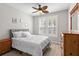 Serene bedroom featuring a ceiling fan, wooden dresser, and a light-filled window with plantation shutters at 130 River Landing Dr # 9104, Charleston, SC 29492
