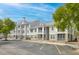 Attractive condo building with beige siding, white trim, screened porches, reserved parking, and mature landscaping at 130 River Landing Dr # 9104, Charleston, SC 29492