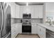 Modern kitchen with white cabinets, stainless steel appliances, and gray backsplash for a clean, sleek look at 130 River Landing Dr # 9104, Charleston, SC 29492