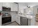 Bright kitchen featuring stainless steel appliances, white cabinets, and a view to a living room at 130 River Landing Dr # 9104, Charleston, SC 29492