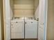 An interior view of laundry closet containing white washer and dryer units with white wire shelf above at 1300 Park West Blvd # 519, Mount Pleasant, SC 29466