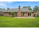Brick home exterior featuring green lawn, mature trees, and blue sky background at 1304 Pinyon Pine Dr, Ladson, SC 29456