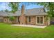 Brick home with a spacious backyard, green grass, and mature trees at 1304 Pinyon Pine Dr, Ladson, SC 29456