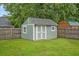 A quaint storage shed with double doors and a window in a well kept backyard at 1304 Pinyon Pine Dr, Ladson, SC 29456